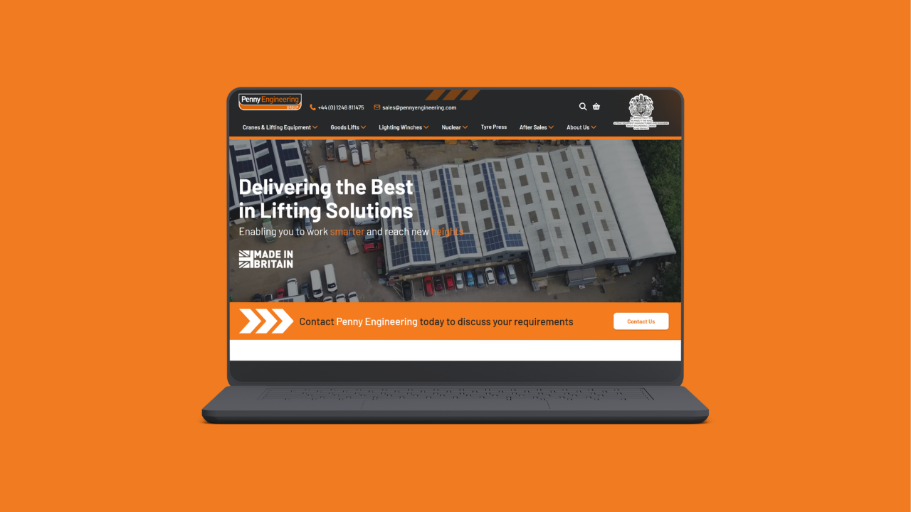 A laptop displays the Penny Engineering website featuring an aerial view of an industrial building with text promoting lifting solutions, set against an orange background.