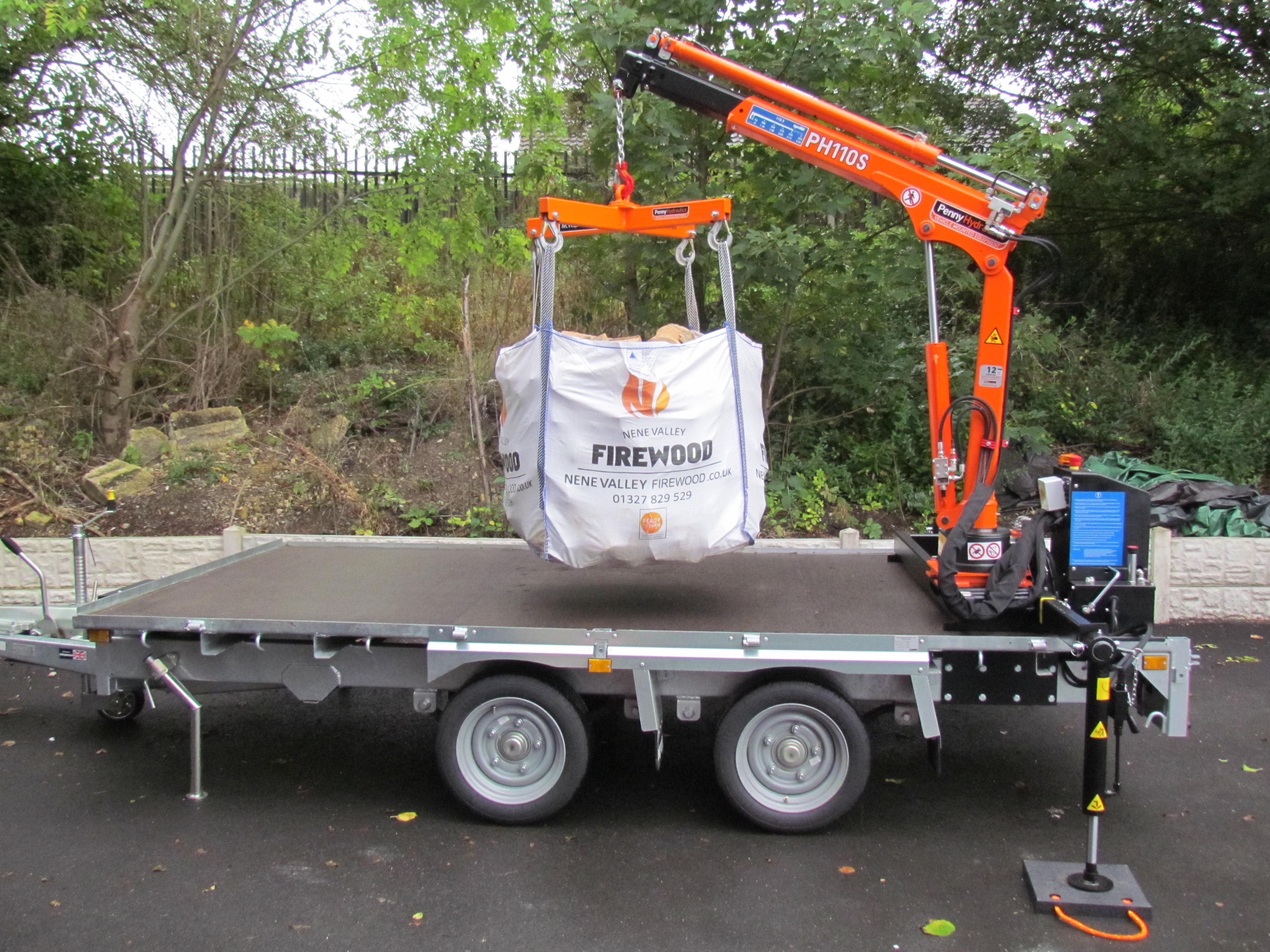 A flatbed lorry with a red crane attachment is parked on a road near trees. The image is distorted with digital glitches obscuring parts of the vehicle and background.