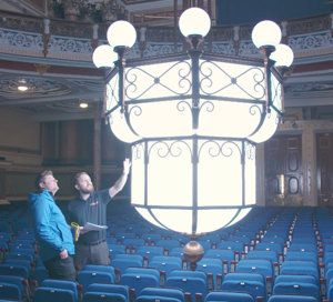 A chandelier lowered and being examined.