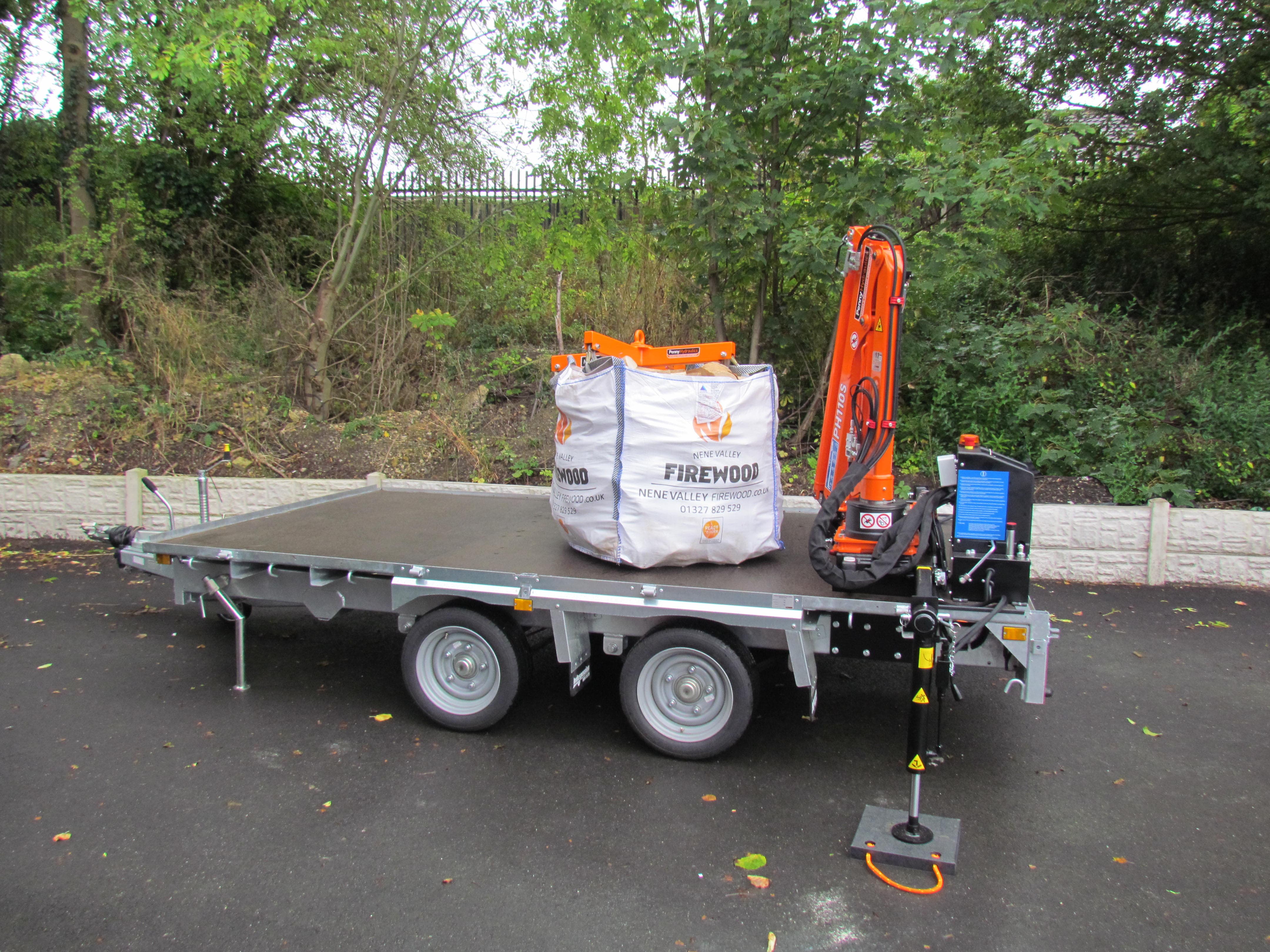 A small, red digger is parked on a paved area next to some greenery and bushes. The image is distorted with digital glitches, making parts of the scene unclear.